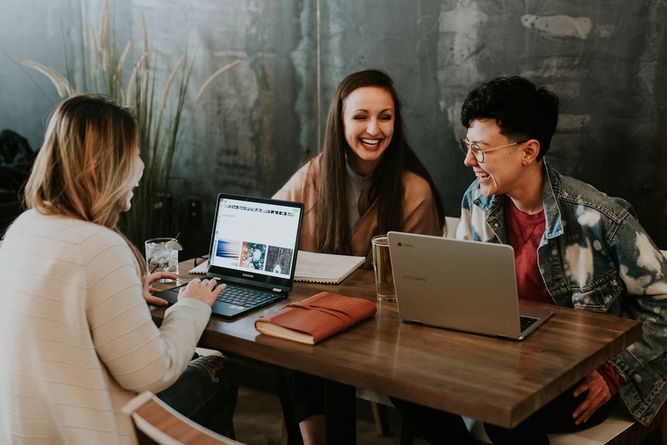 Grupo colaborando con computadoras portátiles